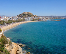Vista panorámica de Águilas, Murcia, con su playa urbana, paseo marítimo y el castillo sobre la colina.